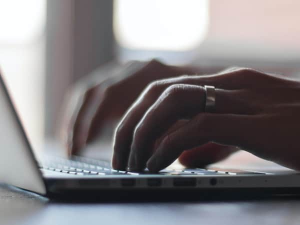 hands typing on laptop keyboard